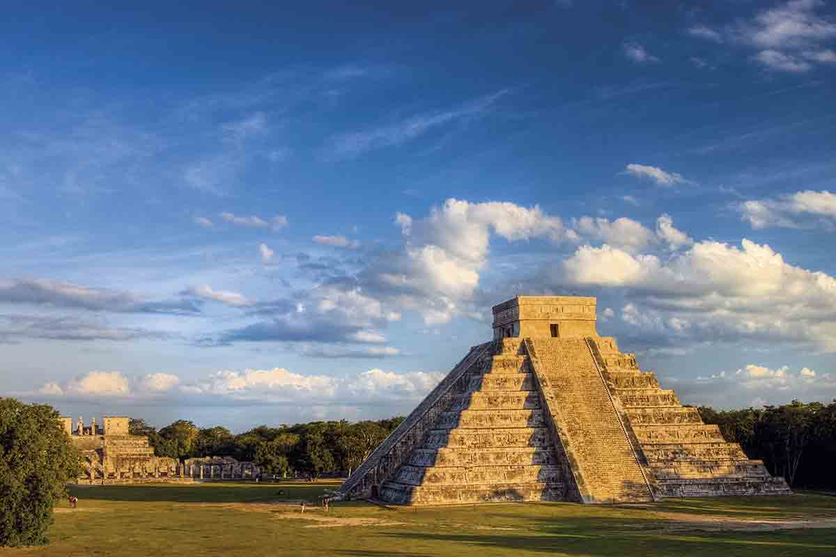 This image showcases the majestic ruins of Chichen Itza, set against a breathtaking backdrop of a vibrant blue sky. It naturally invites history enthusiasts to embark on an exclusive private tour, exploring the rich cultural and architectural wonders of this ancient Mayan site.
